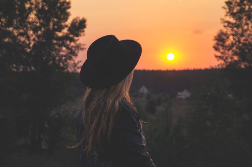 Woman staring at a beautiful sun